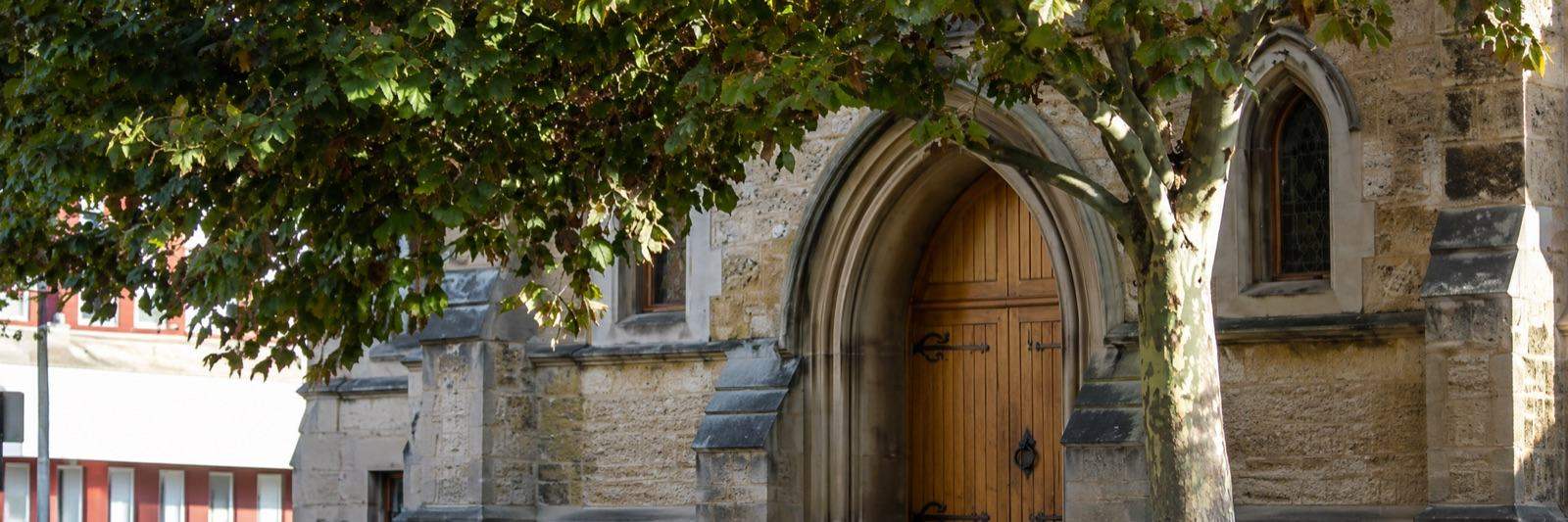 A historic Fremantle church framed by leaves, near The Port Counselling Centre